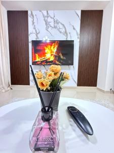 a vase with flowers in front of a fireplace at Opera67 Spacious & Central in Ghubrah