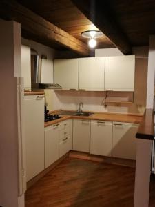 een keuken met witte kasten en een houten plafond bij ARC Apartments in Bologna