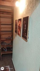 ein Flur mit vier Bildern an einer Wand in der Unterkunft Chalé Diamante c /AR in Volta Redonda