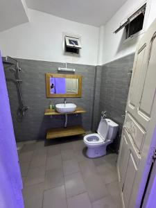 a bathroom with a toilet and a sink at Keur NKH in Ouoran +7 photos