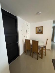 a dining room with a table and a clock on the wall at APARTAMENTO Premium in Ibagué