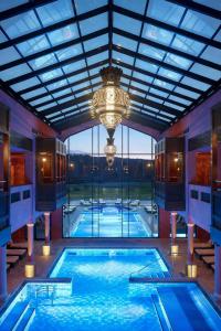 ein großes Schwimmbad mit einem Kronleuchter in einem Gebäude in der Unterkunft SarreUlysse Chic Apartment Perfect for Business or Leisure in Sarreguemines in Sarreguemines