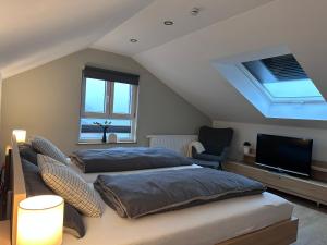 ein Schlafzimmer mit zwei Betten und einem Flachbildfernseher in der Unterkunft Haus Martha - Top Modernes Apartment in der Natur in Willingen