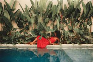 a man and a woman sitting next to a swimming pool at NORI Boutique Villas Uluwatu - Breakfast Available in Uluwatu