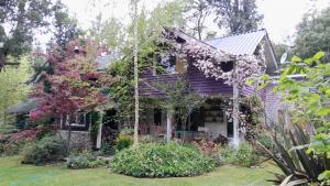 a purple house with flowers in the yard at Dodo House in Villa La Angostura