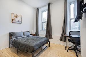 een slaapkamer met een bed, een bureau en ramen bij Chic Studio pour 2- 7 jours- Parking gratuit in Montreal