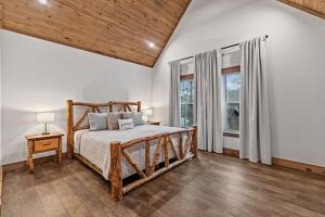 een slaapkamer met een houten bed en een groot raam bij Fireside Living in Galloway