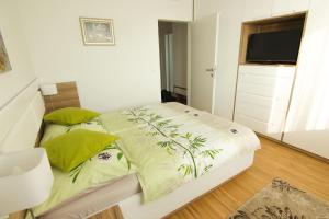 ウィーンにあるVienna Apartments Hauptbahnhofの白いベッド(緑の枕付)が備わるベッドルームです。
