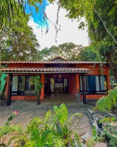 een oranje huis midden in een bos bij Casa de Cura in Pipa