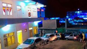 un groupe de voitures garées devant un bâtiment la nuit dans l'établissement Ghani Palace Hotel Kalam, à Kārandūkai