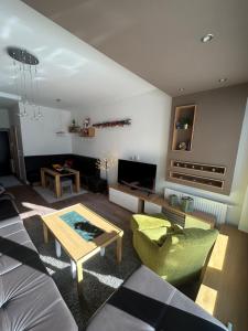 ein Wohnzimmer mit Sofa und Tisch in der Unterkunft Sunny Escape Bjelašnica in Ivišovo Greblje