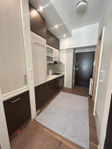 eine Küche mit weißen Schränken und einem weißen Teppich in der Unterkunft Sunny Escape Bjelašnica in Ivišovo Greblje + 5 Fotos