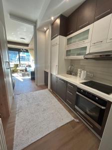 eine Küche mit braunen Schränken und einem weißen Teppich in der Unterkunft Sunny Escape Bjelašnica in Ivišovo Greblje