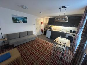 Una sala de estar con un sofá y una cocina. en Chloes Holiday Apartments, en Inverness