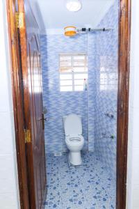 une salle de bain carrelée bleue avec des toilettes à l'intérieur dans l'établissement Kasarani Studio Apartment, à Nairobi 10 autres photos