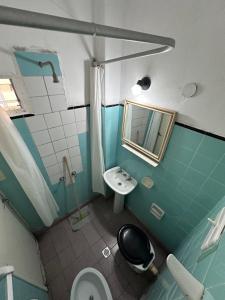 een badkamer met een wastafel, een toilet en een spiegel bij Hotel Saona in Mar del Plata +58 foto's