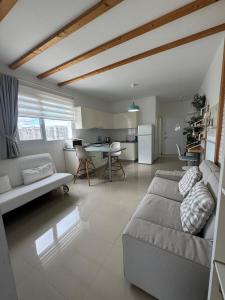 a living room with a couch and a kitchen at Caesar Resort & SPA & Apartments Spacious Studio in Avgorou