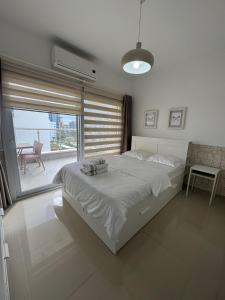 a bedroom with a bed and a large window at Caesar Resort & SPA & Apartments Spacious Studio in Avgorou
