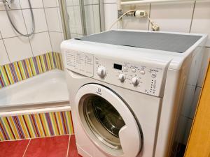 a washing machine in a bathroom next to a tub at Stylish Apartment near Airport in Schwechat