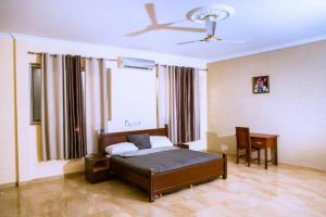 a bedroom with a bed and a desk and a window at Home from Home Ghana in Accra