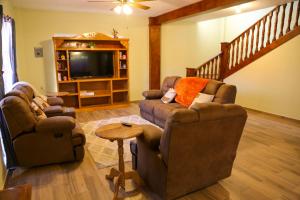 a living room with two chairs and a tv at Casa Naranja in Ciudad Fernández