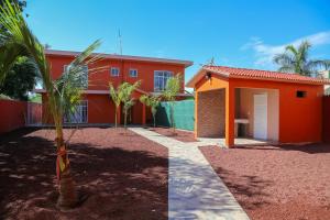 a house with a palm tree in front of it at Casa Naranja in Ciudad Fernández