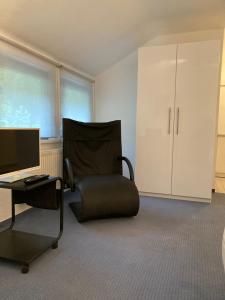 een kamer met een stoel en een bureau met een computer bij Monteur- oder Wandererwohnung im Hildesheimer Wald in Diekholzen