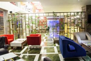 a lobby with red and blue chairs and plants at Neba Royal Hotel in Samsun