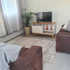 a living room with a tv and a couch at Montebelle casa1 in Porangaba