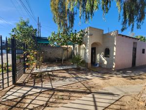 una casa con una recinzione e un albero di Casa Villafontana a Mexicali