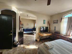 una camera da letto con un letto, una scrivania e una televisione di Casa Villafontana a Mexicali
