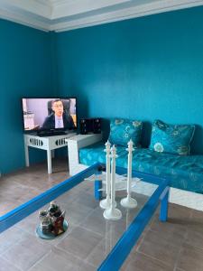 a blue living room with a couch and a tv at Beachfront villa sidi ouarzeg in Sidi Ouarsik