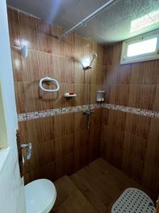 a bathroom with a toilet and a shower with wooden walls at Beachfront villa sidi ouarzeg in Sidi Ouarsik +23 photos