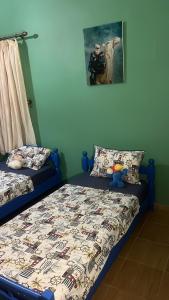 a bedroom with two beds and a picture on the wall at Beachfront villa sidi ouarzeg in Sidi Ouarsik