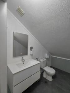 un bagno bianco con lavandino e WC di Hostel Rosa a São Pedro de Muel