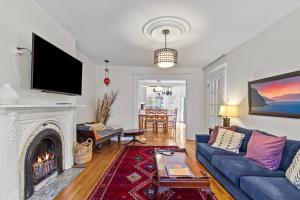 een woonkamer met een blauwe bank en een open haard bij House Patrick 4Bd Loft Style Parking in St. John's