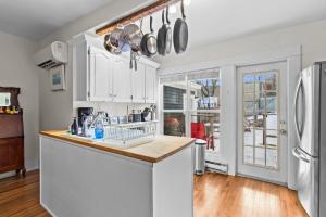 a kitchen with white cabinets and a white refrigerator at House Patrick 4Bd Loft Style Parking in St. John's