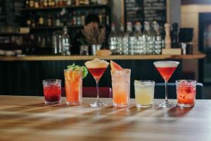 a group of different cocktails sitting on a bar at Canalta Hotel Restaurant Bar in Jaipur