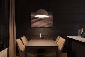 a dining room table with chairs and aendant light at Le Chalet Lingonberry D14 Ski-in Ski-out by Aavalevi in Levi +18 photos
