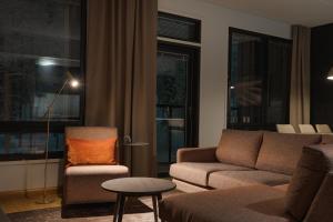 a living room with a couch and a chair at Le Chalet Lingonberry D14 Ski-in Ski-out by Aavalevi in Levi