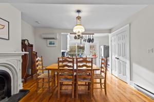 een eetkamer met een tafel en stoelen en een open haard bij House Patrick 4Bd Loft Style Parking in St. John's +25 foto's