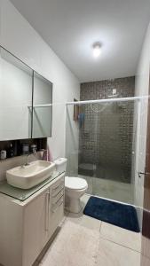 een badkamer met een wastafel, een toilet en een douche bij Jardim dos Ipês in Araranguá +12 foto's