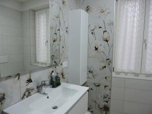 een badkamer met een wastafel en bloemenbehang bij L'Ora del Bianco in Nave San Felice