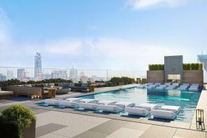 a swimming pool with white lounge chairs on top of a building at 20th FL 1BR - Heated Pool - Gym - Bar - Balcony in Austin
