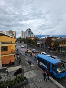 a blue bus driving down a busy city street at Apartaestudio con vista a AV Santander Manizales in Manizales +7 photos