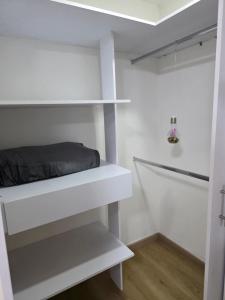 a bedroom with white shelves and a bed at Apartaestudio con vista a AV Santander Manizales in Manizales