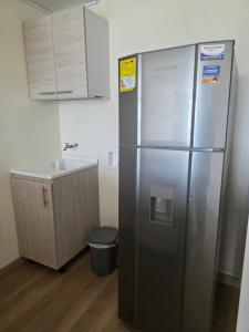 a kitchen with a stainless steel refrigerator and a sink at Apartaestudio con vista a AV Santander Manizales in Manizales