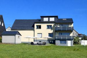 ein großes Gebäude mit Sonnenschirmen davor in der Unterkunft Haus Martha - Top Modernes Apartment in der Natur in Willingen
