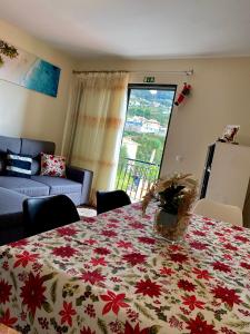 a living room with a table with a flowered table cloth at Casa Gomes in Calheta