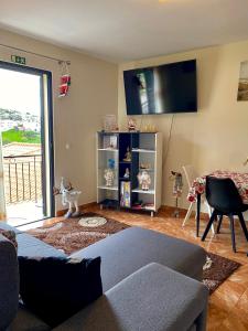 a living room with a couch and a flat screen tv at Casa Gomes in Calheta